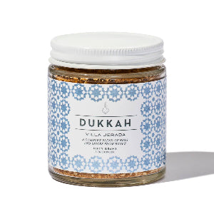 Jar of Villa Jerada dukkah with a decorative label on a white background